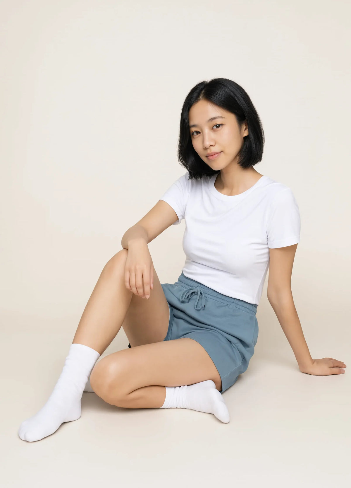 nabi Sweat Shorts in Washed Chambray (washed blue), seated on the floor