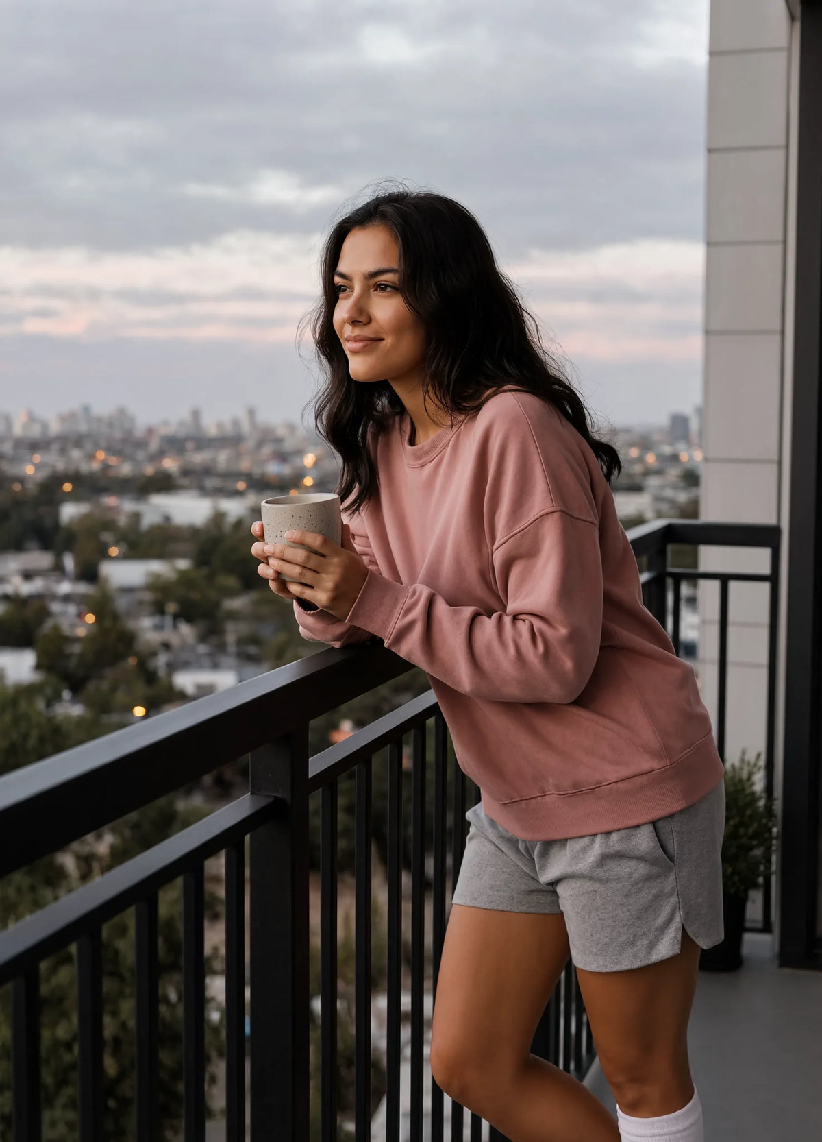 nabi Wash Sweatshirt in Ember Rose (dusty rose), balcony at dusk, lifestyle