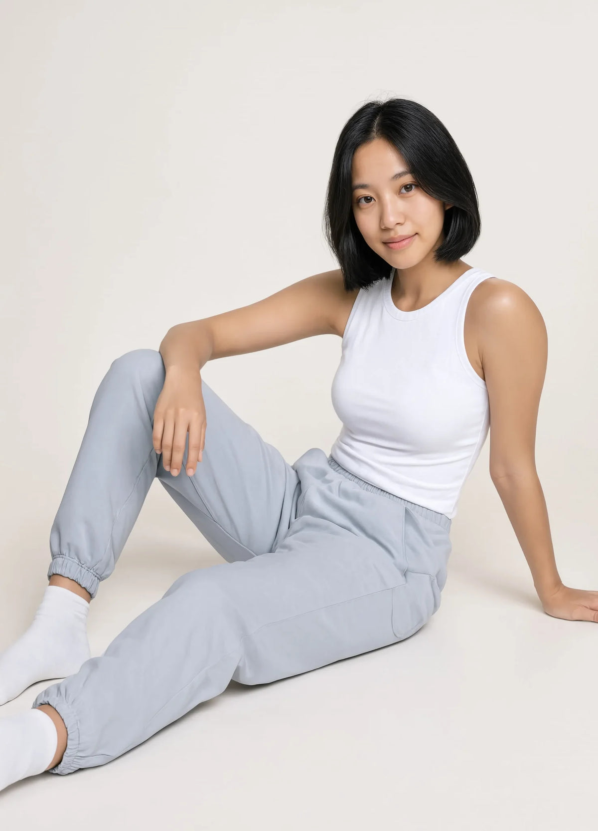 nabi Track Pants in Washed Chambray (washed blue), seated on the floor